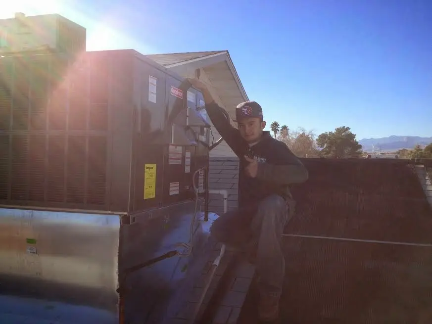 HVAC technician performing HVAC Inspection on a rooftop unit in Houghton